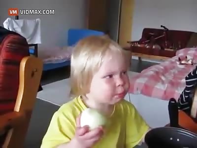 Just a little kid eating an onion.